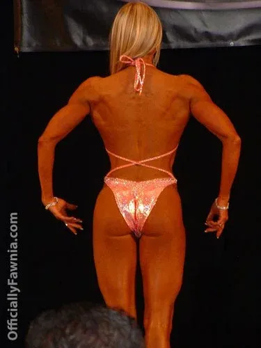 Fawnia posing on stage in a competition bikini at a fitness competition (photo 1)