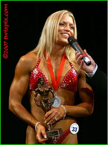 Fawnia posing on stage in a competition bikini at a fitness competition (photo 7)